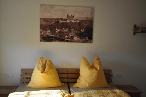 two pillows on a bed with a picture on the wall at D´r Rechenmacher in Michelfeld
