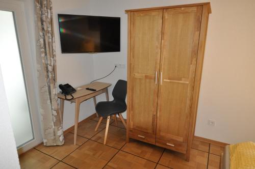 Michelfeld的住宿－D´r Rechenmacher，客房设有木制橱柜、椅子和桌子。