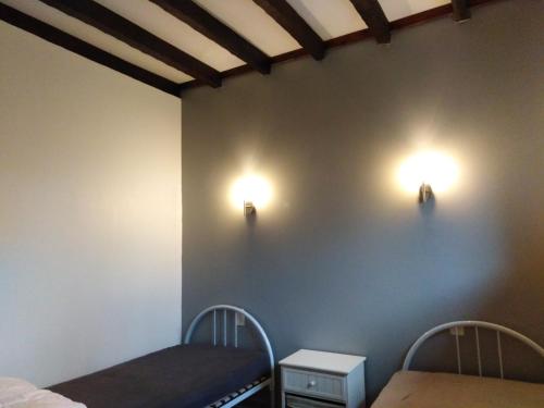 a room with two beds and lights on the wall at GITE IBARLA BORDA in Bidarray