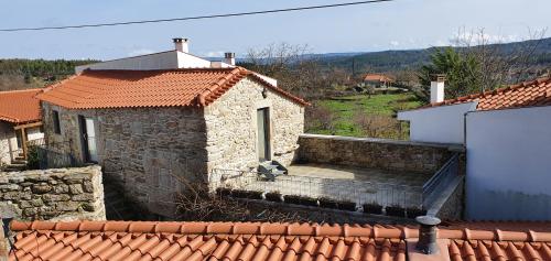 a small stone building with a stairway to a house at Casas de Campo da Barroca in Tabosa