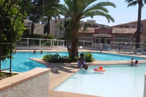 une personne assise dans une piscine avec un frisbee dans l'établissement Appartamento vista splendida Residence du Golf, au Golfe-Juan