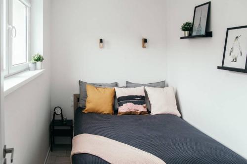 a bed with many pillows on it in a room at Hello Apartments RAI Rajska in Gdańsk