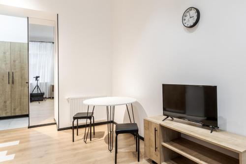 a living room with a tv and a table and chairs at Modern Apartment in the Old City in Lviv