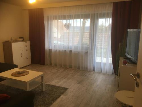 a living room with a table and a large window at Ferienwohnung Bergkristall in Forchheim