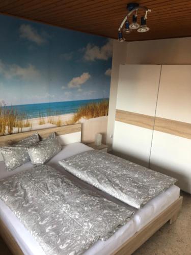 ein Schlafzimmer mit einem Bett und einem Gemälde des Strandes in der Unterkunft Ferienwohnung Bergkristall in Forchheim