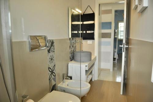 a bathroom with a white toilet and a sink at dimoradamare in Villaggio Azzurro