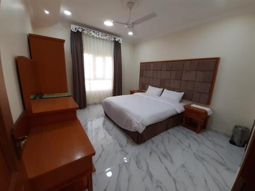 A bed or beds in a room at AL JOOD HOTEL APARTMENT