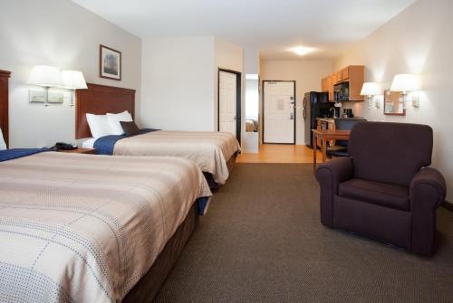 une chambre d'hôtel avec deux lits et une chaise dans l'établissement Candlewood Suites Craig-Northwest by IHG, à Craig
