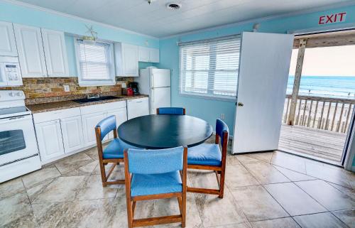 a kitchen with a table and chairs and the ocean at Outer Banks Motel in Buxton