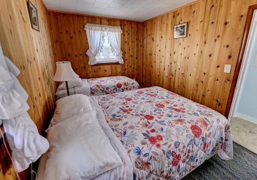 a bedroom with two twin beds and a window at Outer Banks Motel in Buxton