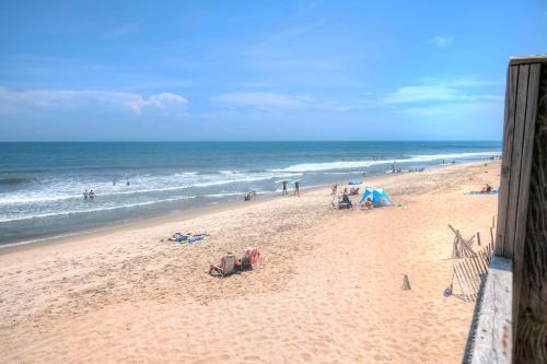 a beach with a group of people and the ocean at Outer Banks Motel in Buxton