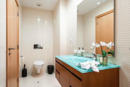 een badkamer met een blauwe wastafel en een toilet bij OCEANVIEW Luxury Amazing Views and Pool in Olhão