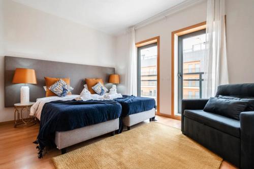 een slaapkamer met een groot bed en een bank bij OCEANVIEW Luxury Amazing Views and Pool in Olhão