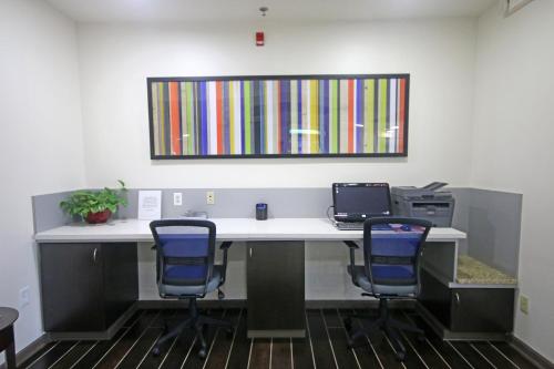 an office with a desk with two chairs and a laptop at Holiday Inn Express Hotel & Suites Greensboro-East by IHG in Greensboro