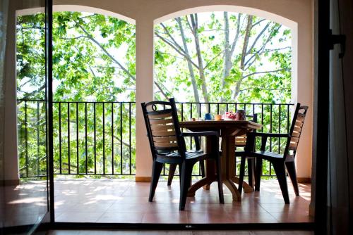 een tafel en stoelen in een kamer met een balkon bij Apartamentos Golf Place in Borriol