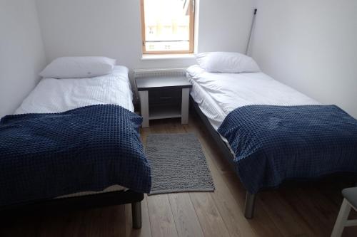 two beds in a room with a desk and a window at Ekskluzywny apartamet Pan Tadeusz III z widokiem na jezioro in Giżycko