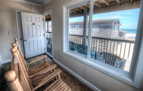 a porch with a rocking chair and a window at Outer Banks Motel in Buxton