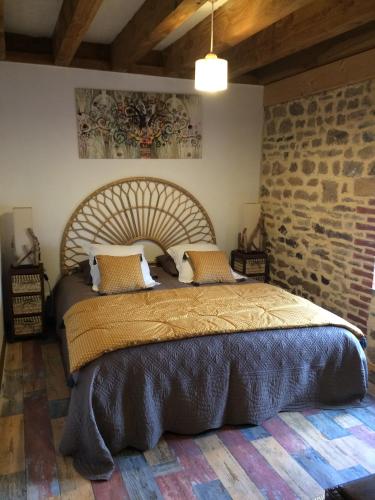 une chambre avec un grand lit avec un mur de briques dans l'établissement Morvan Séjours, à Antully