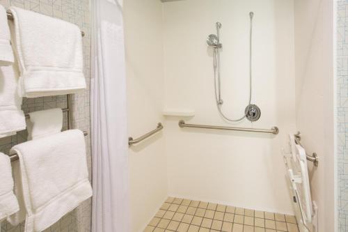 een badkamer met een douche, een toilet en handdoeken bij Holiday Inn Express & Suites Pahrump, an IHG Hotel in Pahrump