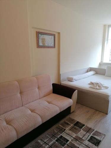 a living room with a couch and a bed at Hotel Lago Peshtera in Peshtera