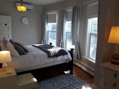 a bedroom with a bed and two windows at Hillside Landing B&B in Digby