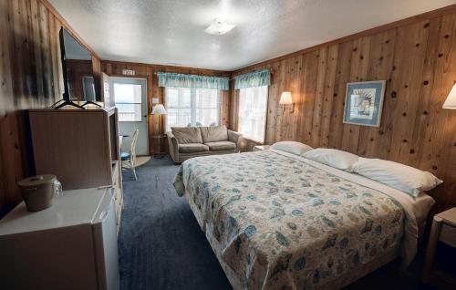 a bedroom with a bed in a room with wooden walls at Outer Banks Motel in Buxton