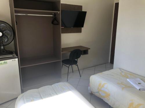 a small bedroom with a bed and a desk at Hotel de Minas in Caxambu