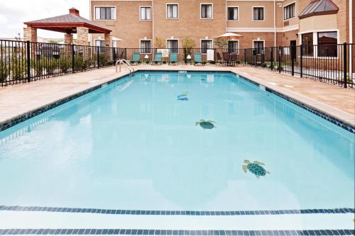 a swimming pool at a hotel with blue water at Staybridge Suites Oklahoma City-Quail Springs by IHG in Oklahoma City