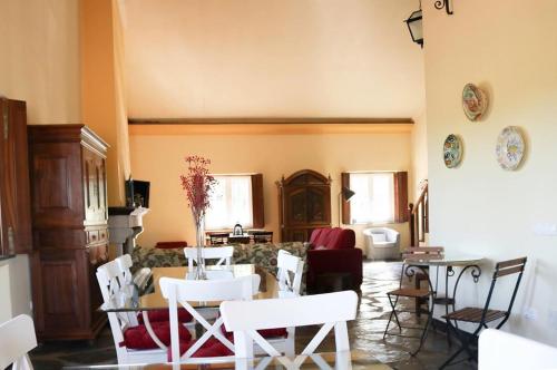 a living room with white chairs and a table at Monte da Floresta B&B in Ferreira do Alentejo