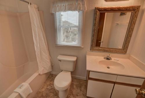 a bathroom with a toilet and a sink and a mirror at Outer Banks Motel in Buxton