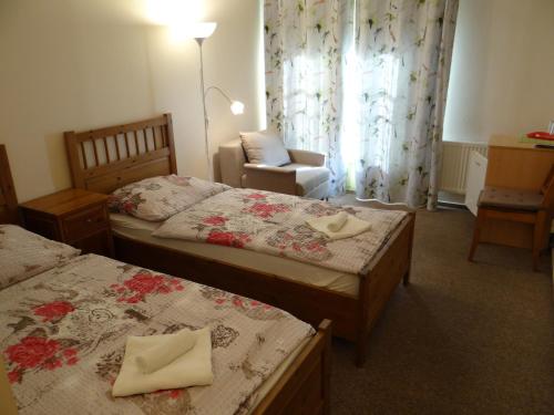 a hotel room with two beds and a chair at Pension Europa in Prague