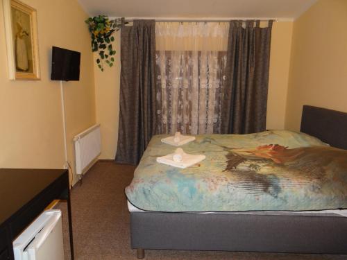 a bedroom with a bed with two hats on it at Pension Europa in Prague