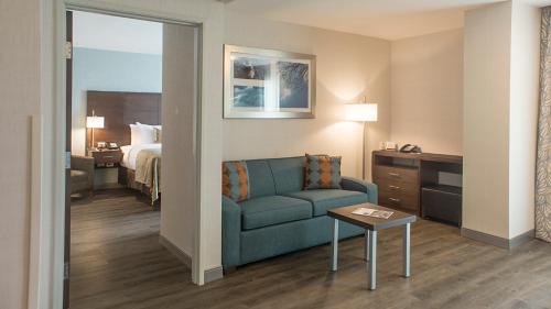 a hotel room with a couch and a bed at Staybridge Suites Puebla by IHG in Puebla