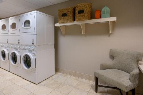 a laundry room with a washing machine and a chair at Staybridge Suites Wilmington - Brandywine Valley by IHG in Glen Mills