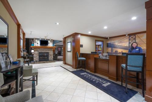 a man standing in a room with a bar at Staybridge Suites Wilmington - Brandywine Valley by IHG in Glen Mills