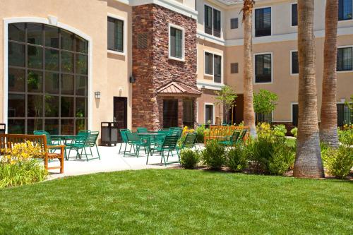 a patio with chairs and tables in front of a building at Staybridge Suites Palmdale by IHG in Palmdale