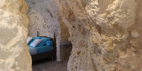 a room with a couch in a rock wall at Caves du Coteau 3 in Lunay