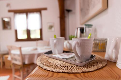 une table en bois avec trois tasses sur un plateau dans l'établissement L'instant jardin, à Saint-Mars-de-Coutais