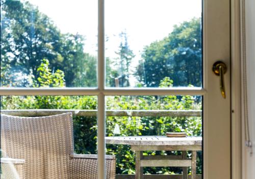 an open window with a table and a chair at Dragsholm Slot in Hørve