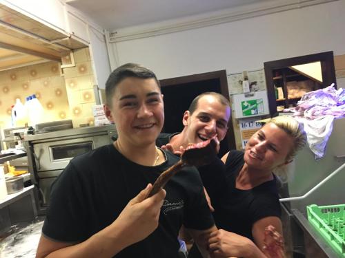 a group of three people holding a piece of food at Weinhotel Kirchenwirt in Gols