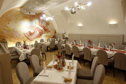 a dining room with tables and chairs and a mural at Hotel Restaurant zur Post in Melk