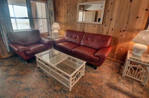 a living room with a leather couch and a coffee table at Outer Banks Motel in Buxton