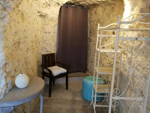 a room with a chair a table and a ladder at Caves du Coteau 3 in Lunay