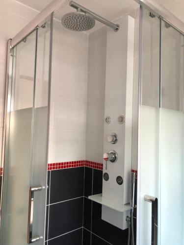 um chuveiro com uma porta de vidro na casa de banho em La Petite Maison em Brest