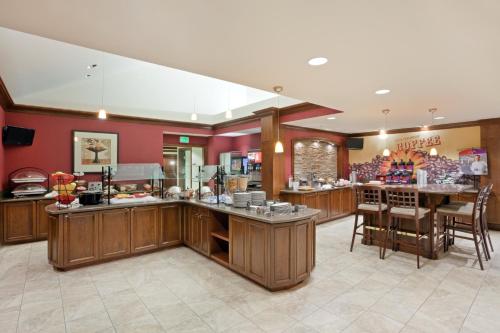 una cocina con armarios de madera y un bar en un restaurante en Staybridge Suites Everett - Paine Field, an IHG Hotel, en Mukilteo