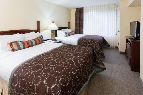 a hotel room with two beds and a television at Staybridge Suites Everett - Paine Field by IHG in Mukilteo