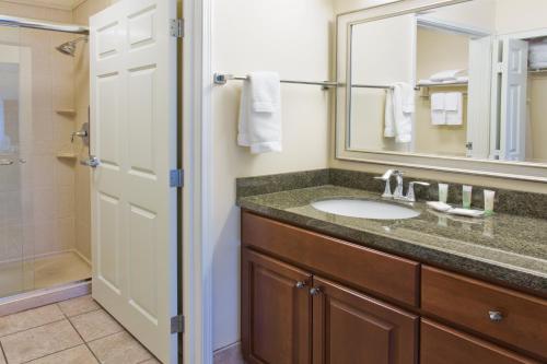 a bathroom with a sink and a mirror and a shower at Staybridge Suites Everett - Paine Field by IHG in Mukilteo
