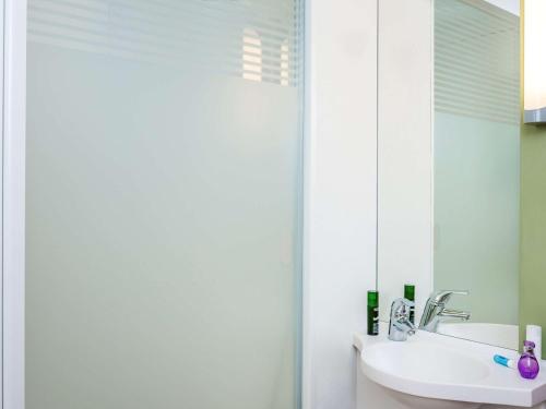 La salle de bains est pourvue d'un lavabo et d'un miroir. dans l'établissement ibis budget Saint-Maurice, à Saint-Maurice