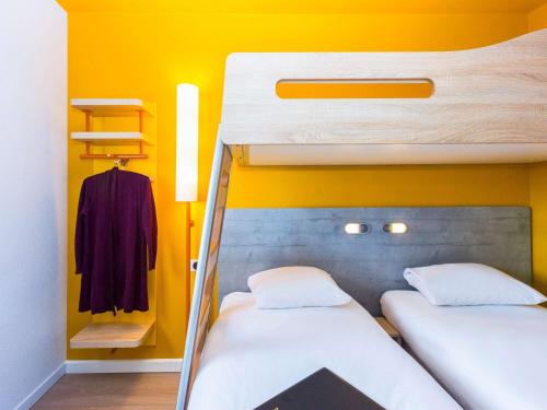 two bunk beds in a room with yellow walls at ibis budget Fontainebleau Avon in Avon