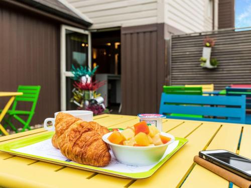 - une table avec un bol de pain et un bol de fruits dans l'établissement ibis budget Berck Sur Mer, à Berck-sur-Mer